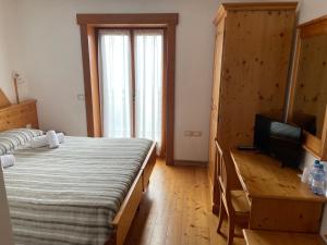 a bedroom with two beds and a flat screen tv at Rifugio Predaia Ai Todes'ci in Tres