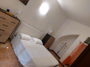 una piccola camera con letto e cassettiera di Casa Coccinella a Nocera Umbra