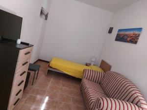 una piccola camera con divano e letto di Casa Coccinella a Nocera Umbra