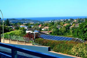 uma fila de painéis solares em cima de uma casa em Blue Sea Guest House em East London