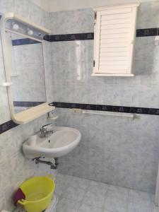 ein Bad mit einem Waschbecken und einem Spiegel in der Unterkunft VisitPonza - La tana di Bacco in Ponza