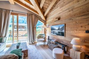 una sala de estar con paredes de madera y una gran ventana. en Apartment Celosia Chamonix - by EMERALD STAY en Chamonix-Mont-Blanc
