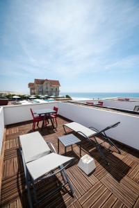 a balcony with a table and chairs and the ocean at Le Grand Hotel de la Plage in Biscarrosse-Plage