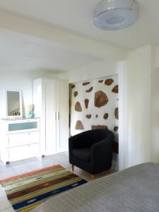 a living room with a black chair and a mirror at Rose Self Catering in Beau Vallon