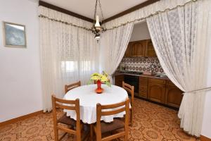 una cocina con una mesa con un jarrón de flores. en Apartment Luketa, en Primošten