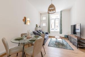 a living room with a table and a couch at Le Grain de Sable in Thionville