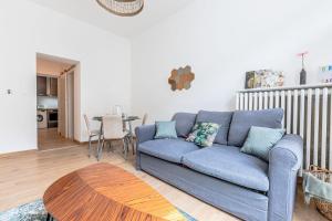 uma sala de estar com um sofá azul e uma mesa em Le Grain de Sable em Thionville