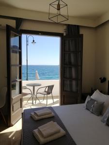OASIS APARTMENTS في Livadia: غرفة نوم مع سرير وإطلالة على المحيط