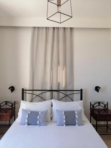 ein Schlafzimmer mit einem großen weißen Bett mit weißen Kissen in der Unterkunft OASIS APARTMENTS in Livadia