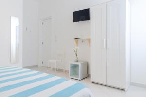 1 dormitorio con 1 cama y TV en la pared en Vidamarina - Camere al Mare en Torre Lapillo