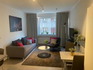 ein Wohnzimmer mit einem Sofa, Stühlen und einem Tisch in der Unterkunft FlatDeCologne SunSet in Köln