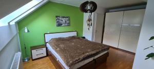 a bedroom with a green wall with a bed in it at Rozmarin Bled in Bled