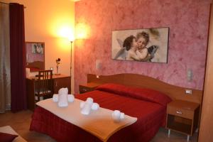 una habitación de hotel con una cama roja y una foto infantil en la pared en B&B Donjon centro, en Castelbuono