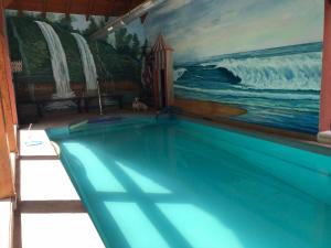 una piscina in una casa con un dipinto di La Casa Malvarrosa ad Ampuero