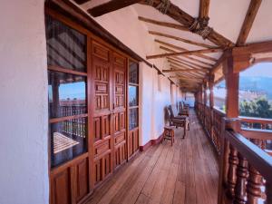 a room with a wooden deck and wooden doors at El Balcón in Cusco