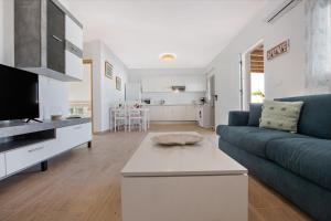 a living room with a blue couch and a kitchen at Vista Paraiso in Tuineje