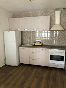 a kitchen with white cabinets and a white refrigerator at anastasia 3 in Mediaş