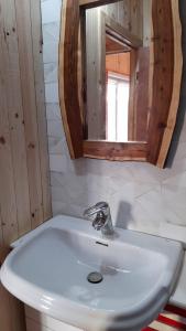 lavabo blanco en el baño con espejo en Cabaña La Puntilla, en Vichuquén