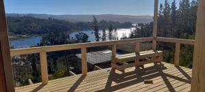 a balcony with a bench and a view of a lake at Cabaña La Puntilla in Vichuquén