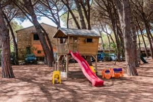 a playground with a house and a slide at Villa Bolgherello in Marina di Bibbona