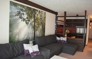 a living room with a couch and a large painting at Ferienwohnung Engelberg in Engelberg
