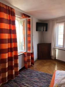 a room with curtains and a bed and a television at anastasia 3 in Mediaş