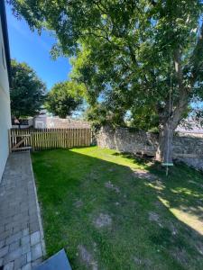 a yard with a fence and a tree at Orchard Lodge -Coastal Retreat, new build, village views, private garden and terrace in Saint Brides Major