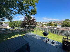 a grill sitting on top of a patio at Orchard Lodge -Coastal Retreat, new build, village views, private garden and terrace in Saint Brides Major
