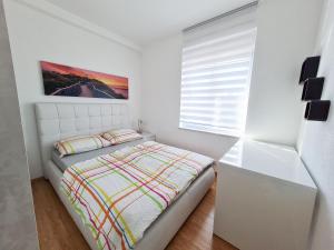 um quarto branco com uma cama e uma janela em Apartment SAJO em Crikvenica