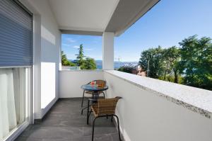 a balcony with a table and chairs on a white wall at Villa Icici in Ičići