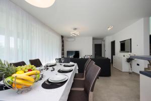 伊齊齊的住宿－Villa Icici，用餐室配有带水果的长桌