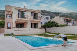 a villa with a swimming pool in front of a house at Villa Forte Mare in Petrovac na Moru