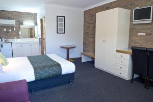 天鹅山Travellers Rest Motor Inn Swan Hill的一间带床和厨房的酒店房间