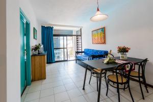 a living room with a table and chairs and a couch at Residence Magnolia in Marina di Bibbona