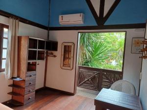 Zimmer mit einem großen Fenster und einem Tisch in der Unterkunft Shanti House Apart in Praia do Forte
