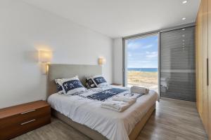 a bedroom with a large bed with a large window at Casa do Azimute by Real Vision in Porto Santo