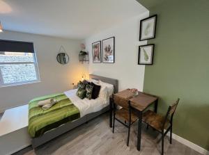 a small bedroom with a bed and a table at The Green Room - Worthing in Worthing