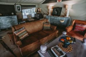 a living room with a couch and a table at Mara Olapa Camp in Masai Mara