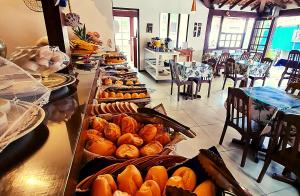 a buffet line with many different types of bread and pastries at Pousada Solar de Geribá in Búzios