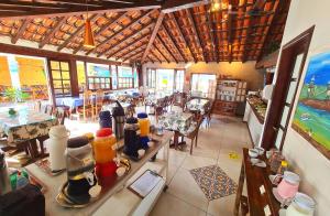 un restaurante con mesas y sillas en una habitación en Pousada Solar de Geribá, en Búzios