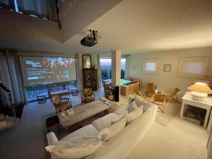 uma sala de estar com um sofá branco e uma televisão em Casa do Cruceiro surfing Costa da Morte em Cayón