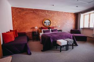 a bedroom with two beds and a couch and a mirror at Penzion Veza in Kremnica