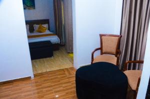 a room with a bedroom with a bed and a chair at J Gibson Hotel in Lagos