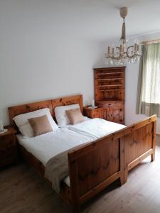 a bedroom with a large wooden bed and a chandelier at Apartment Hörmann in Ardning