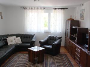 ein Wohnzimmer mit einem Sofa, Stühlen und einem TV in der Unterkunft Apartments Vesna in Opatija