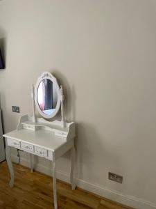 a white dressing table with a mirror on it at The Paramount Hotel in London