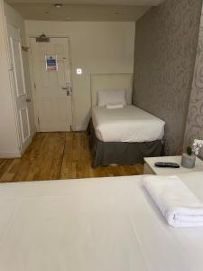 a small room with two beds and a door with a door at The Paramount Hotel in London