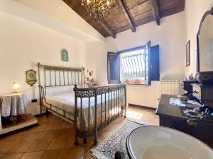 ein Schlafzimmer mit einem Bett und einer Badewanne und einem Fenster in der Unterkunft Baglio Giganti in Alcamo