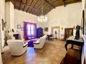 ein Wohnzimmer mit weißen Stühlen und einem Tisch in der Unterkunft Baglio Giganti in Alcamo