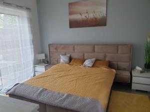 a bedroom with a large bed with a large window at Juventus Apartman in Balatonföldvár